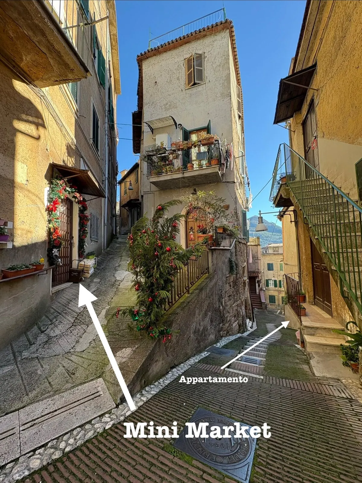 Foto dell’host: il vicolo, con il minimarket e l’ingresso dell’appartamento indicati dalle frecce.