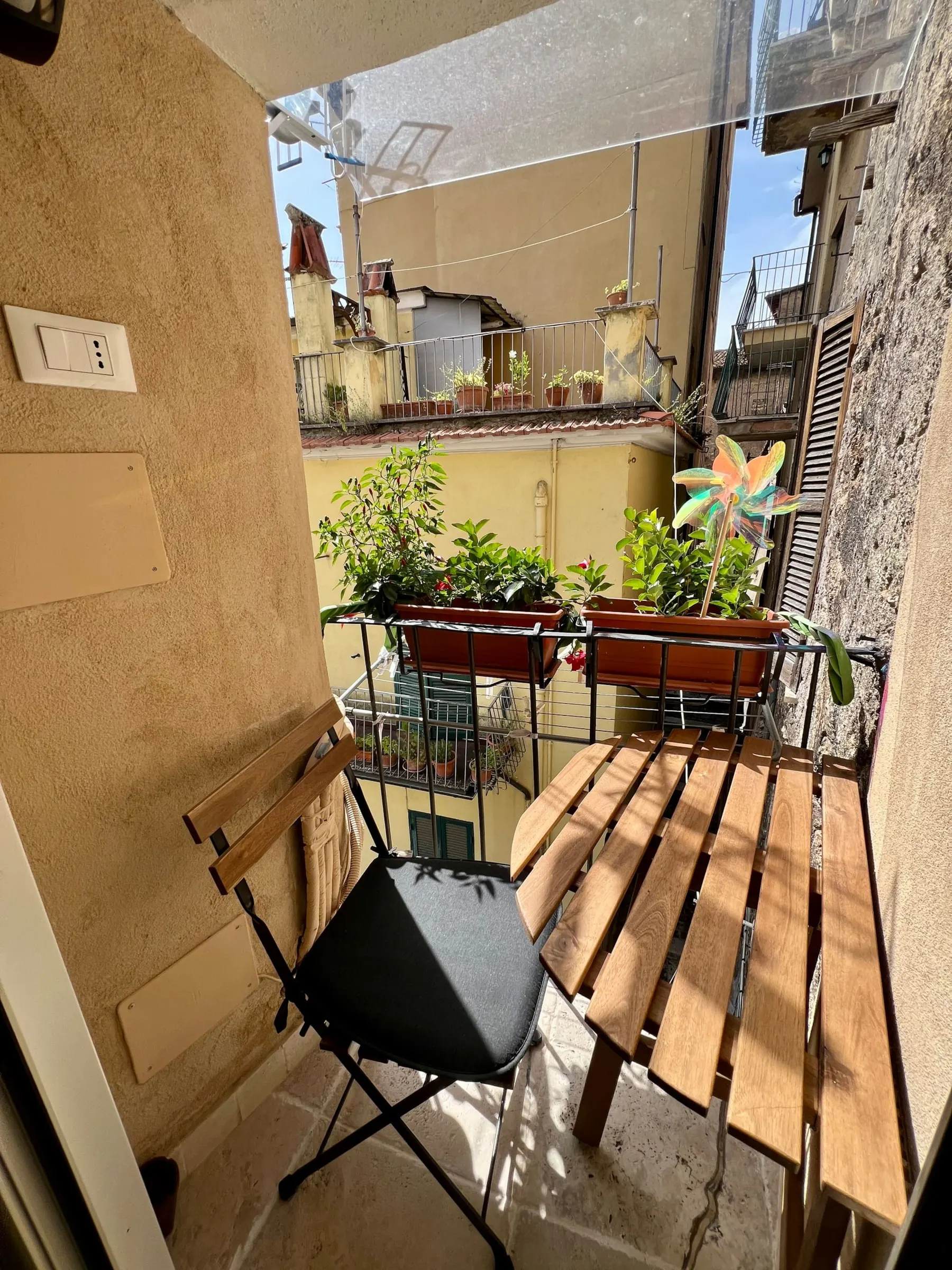 Balcone con tavolino pieghevole affacciato sulle case del borgo