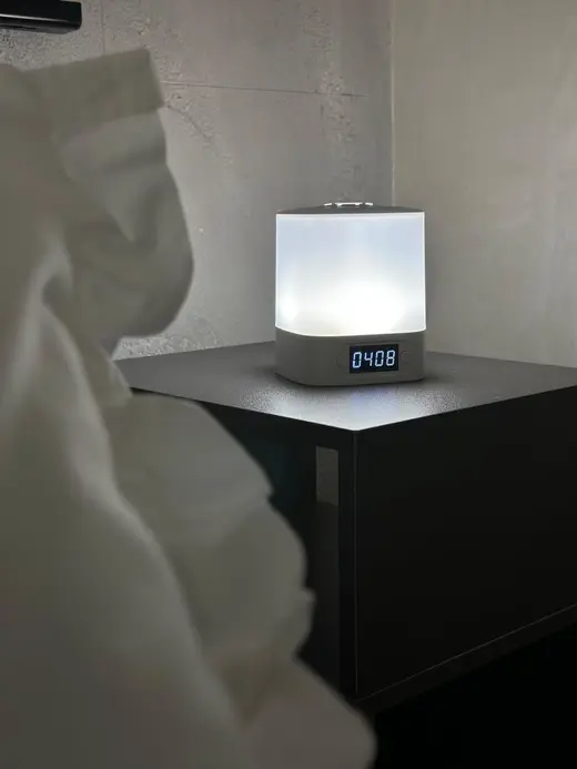 Comodino con lampada smart e ricarica per il telefono