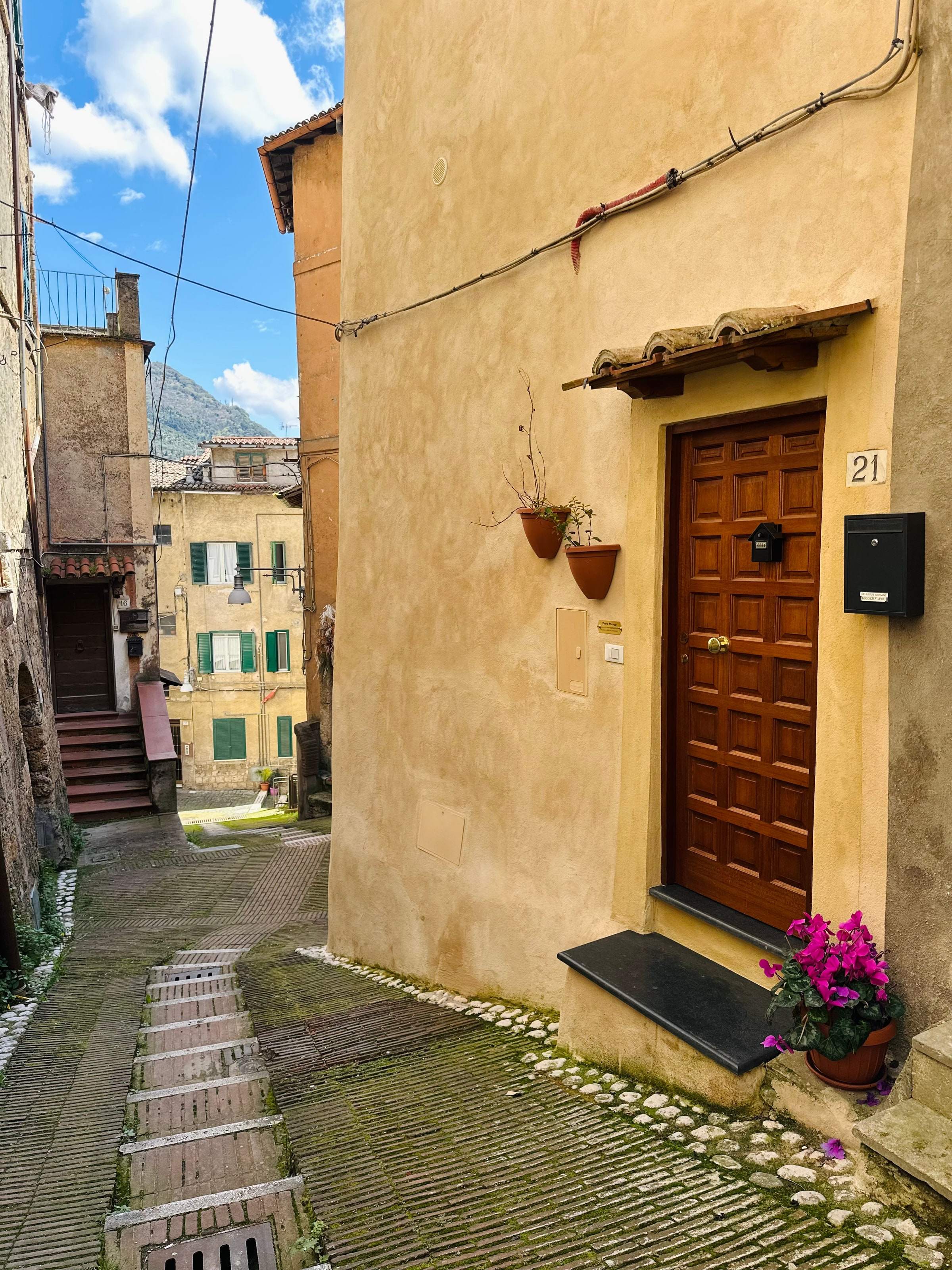 Il vicolo acciottolato del centro storico con la porta di legno de Il Rifugio nel Vicolo