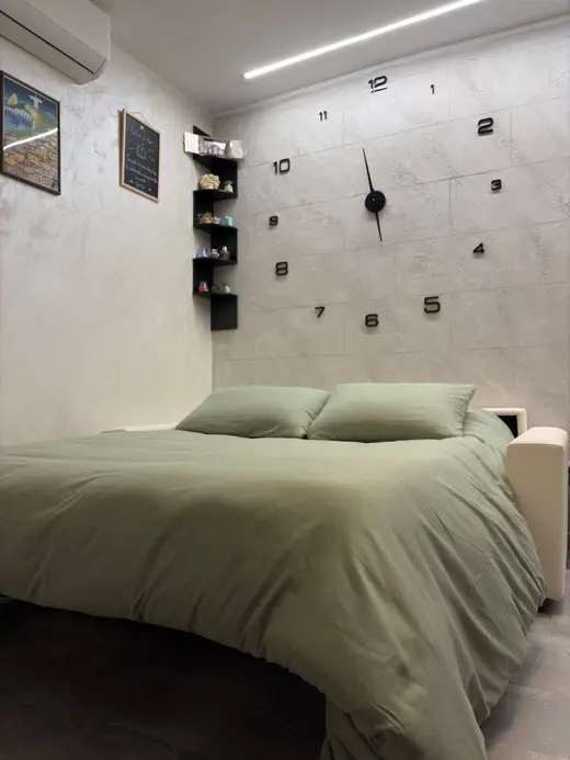 Divano letto aperto nel soggiorno, con orologio da parete