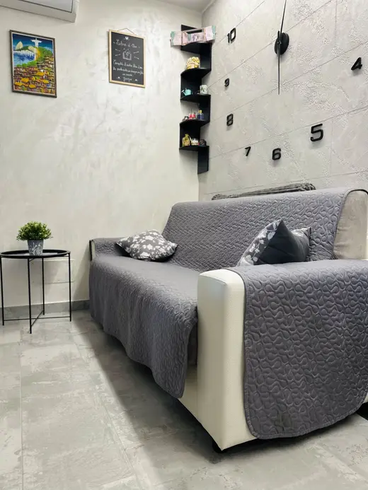 Divano grigio con cuscini e tavolino nero